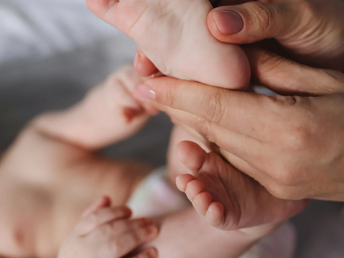 des mains qui massent les pieds d'un bébé