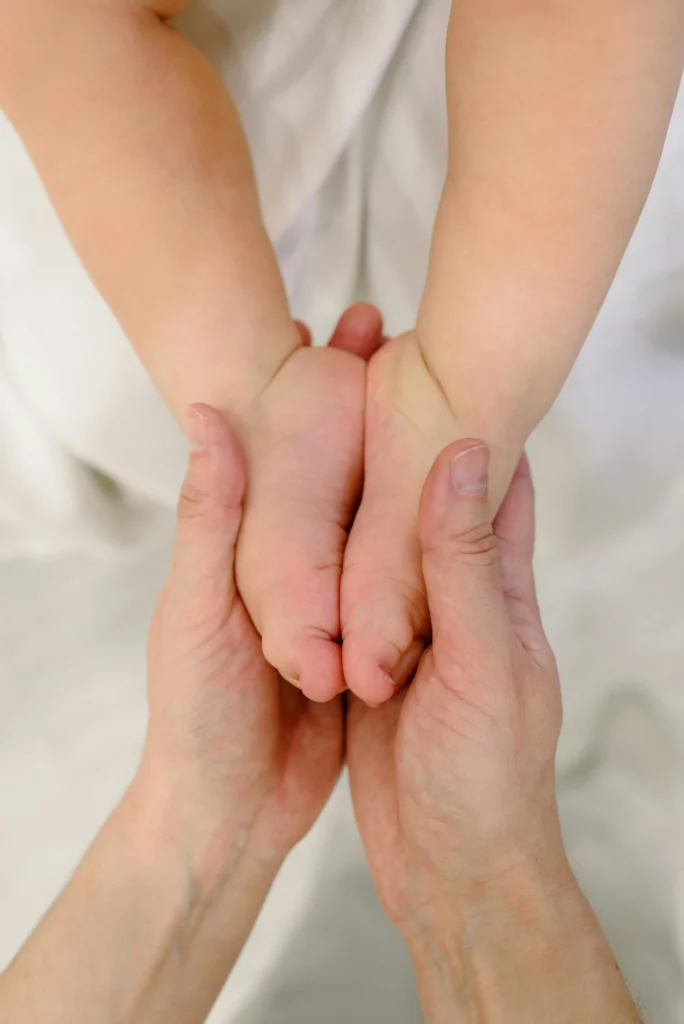 les pieds d'un bébé dans les mains d'une femme